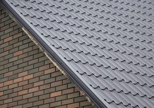 Modern brown roof made of painted metal. Corrugated metal roof and metal roofing industry concept