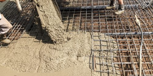 Pouring concrete into the construction of the house. Builders are pouring ready-mixed concrete Pouring concrete into the construction of the house. Builders are pouring ready-mixed concrete