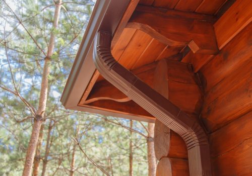 Roof gutter system on log house in forest