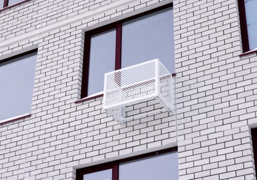 The wall of a brick white apartment building. Air conditioner installation box