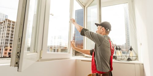 Worker man installs plastic windows and doors with double-glazed white. Worker man installs plastic windows and doors with double-glazed white.